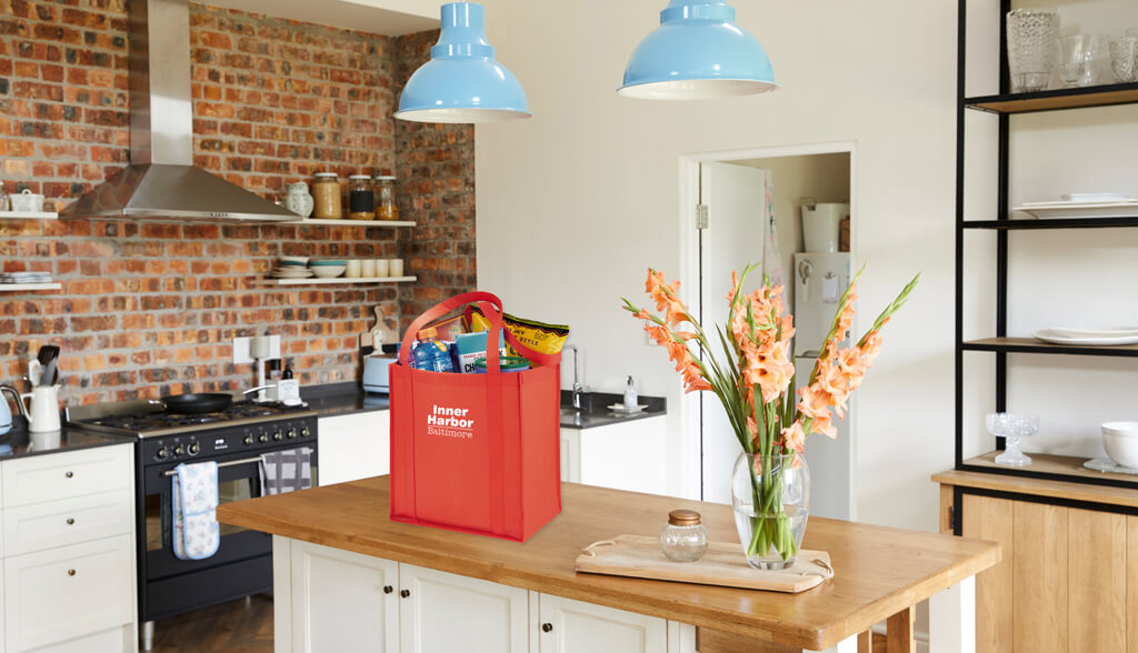 Imprinted Bags, Swag, and Promotional Products for Baltimore, Maryland. red imprinted tote on a kitchen table